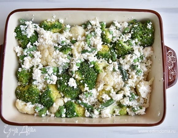 Форму для запекания смазать небольшим количеством растительного масла и выложить овощи с сыром. Равномерно распределить их по всему периметру формы.