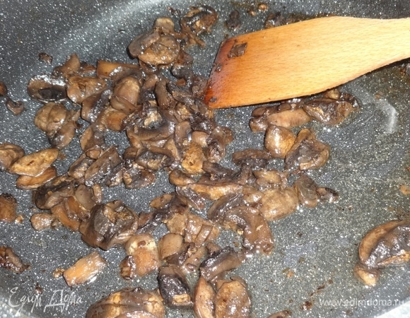 В разогретый жир выложить замороженные грибы и обжарить до готовности.