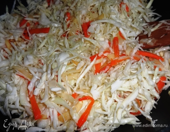 К обжаренным овощам добавить капусту, перемешать. Накрыть сковороду крышкой и тушить овощи на небольшом огне до мягкости капусты.