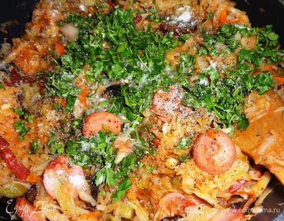 Положить нарезанную зелень, всыпать перец, сахар, влить рассол, перемешать. Попробовать на вкус, если нужно, добавить соли. Тушить солянку еще 5 минут и выключить огонь.