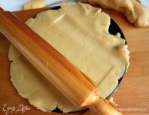 Духовку разогреть до 180°C. Вынуть тесто из холодильника, отделить небольшую часть для бортиков, другую часть раскатать прямо на донышке формы. Иногда такое тесто раскатывают между двумя листами пергаментной бумаги. Смазывать дно формы и борта маслом не надо. Одеть бортик формы.