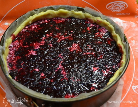 Охлажденное тесто выложить в смазанную маслом форму (я люблю застелить пергаментной бумагой), образуя бортик. На слой теста выложить часть ягод, на них — творожную начинку, сверху — ягоды жимолости.