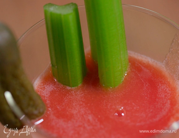 Коктейль перелить через сито в высокий бокал, на его край надеть корнишон, в напиток опустить разрезанный стебель сельдерея.