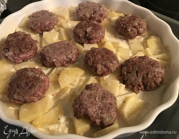 Снимаем фольгу с картошки, выкладываем поверх картофеля тефтели и запекаем еще 10 минут.