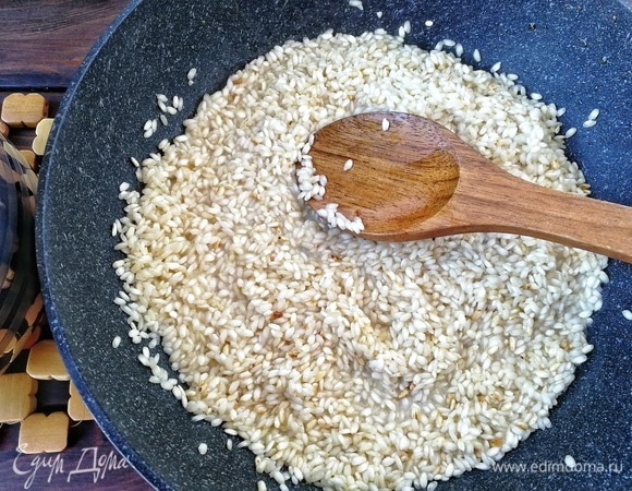 По прошествии 3-х минут наливаем в рис 1 половник горячего рисового миндального молока. Мешаем и даем жидкости впитаться, после чего наливаем следующую порцию молока и так далее, пока молоко не закончится, а рис не приготовится. Главное, не забывайте все время мешать рис и вовремя подливать молоко! Мне потребовалось ровно 25 минут, чтобы рис приготовился до состояния al dente и приобретения необходимой кремовой консистенции. Если у вас все миндальное молоко закончилось, а рис по-прежнему не готов, добавьте постепенно необходимое количество обычного молока или же просто воды.