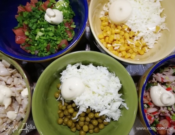Собираем все компоненты салата. Кукурузу и горошек смешиваем с белком и майонезом, лосось — с зеленым луком и майонезом, в кальмар и крабовые палочки также добавляем немного майонеза.