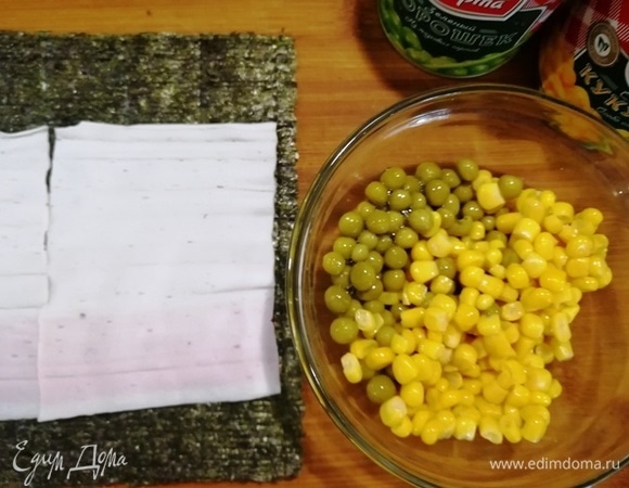 Подготовим кукурузу и зеленый горошек. На лист нори уложим развернутые крабовые палочки.