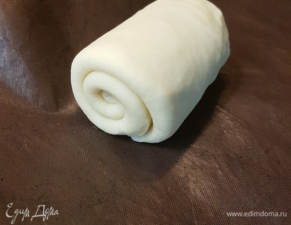 Тесто разделить на 8 частей. Каждую часть раскатать в прямоугольник. Сложить пополам и скатать в рулет. Оставить булочки на час, чтобы поднялись. Выпекать при температуре 200°C 20 минут.