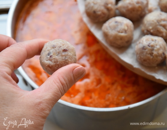 В кипящий бульон по одной выложить охлажденные фрикадельки. Варить, часто помешивая, чтобы фрикадельки не прилипли ко дну. Огонь уменьшить до минимального и томить суп, накрыв крышкой минут 30. При подаче суп посыпать рубленой зеленью и подать специи по вкусу.