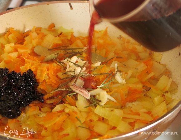 Добавляем раздавленный чеснок, розмарин и ложку варенья из черной смородины. Заливаем вином.