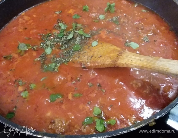Влить бульон, добавить помидоры в собственном соку, предварительно их измельчив (я уменьшила количество помидоров до 700 г). Посолить и поперчить, добавить сахар и чили для остроты, орегано и базилик. Тушить на медленном огне 5 минут, помешивая. Убрать с огня.