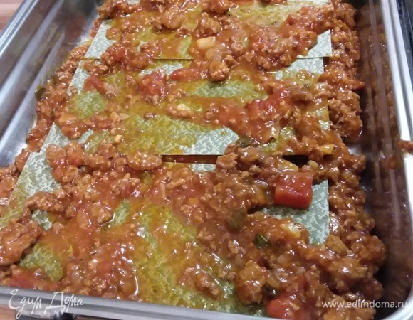 Форму для выпечки смазать маслом. Выложить на дно небольшое количество соуса, затем — листья лазаньи, затем — опять соус. Листья лазаньи у меня такие, которые не нужно предварительно отваривать.