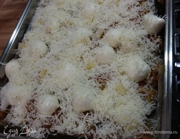 Посыпать натертым пармезаном. Запекать в заранее разогретой до 200°C духовке около 45–50 минут.