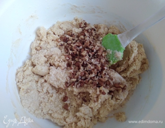 Орехи порубить ножом, часть оставить целыми. Измельченные ввести в тесто, перемешать.