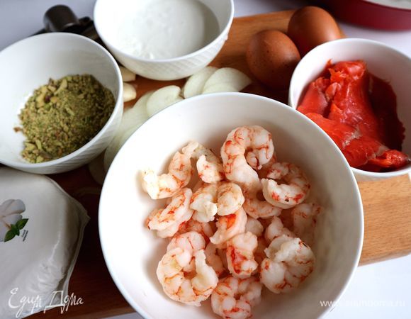 Приготовить все необходимое для начинки. Использовала дикие аргентинские свежезамороженные очищенные креветки крупного размера. Креветки опустить в кипящую подсоленную воду на 2–3 минуты, слить воду, дать остыть. Лук и чеснок почистить. Лук нарезать тонкими полукольцами.