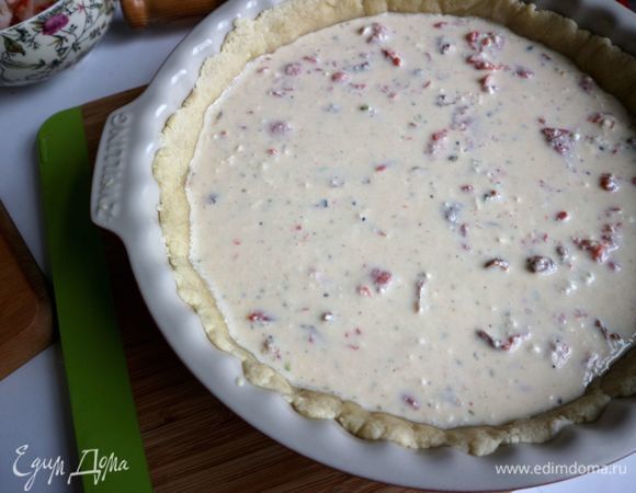 В заливку поместить кусочки рыбы, вяленые помидоры в масле, перемешать. Поместить заливку на тесто.