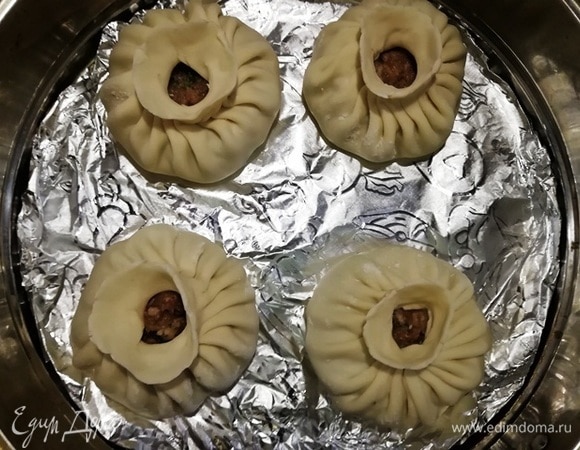 Перед тем как отправить манты вариться на пару, я, руками прижимая, вытянула у них «горлышки». Так тесто стало тоньше, и получились вазочки под масло. Варим в течение 30 минут.