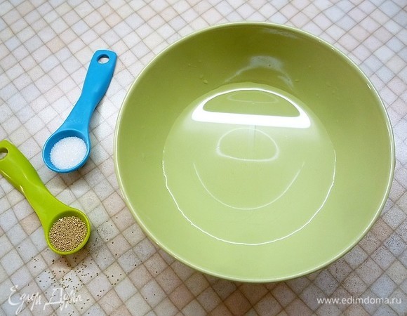 Приготовим тесто для пиццы. В чашку наливаем теплую воду, добавляем дрожжи и сахар, перемешиваем и оставляем на 10–15 минут, чтобы дрожжи активировались.