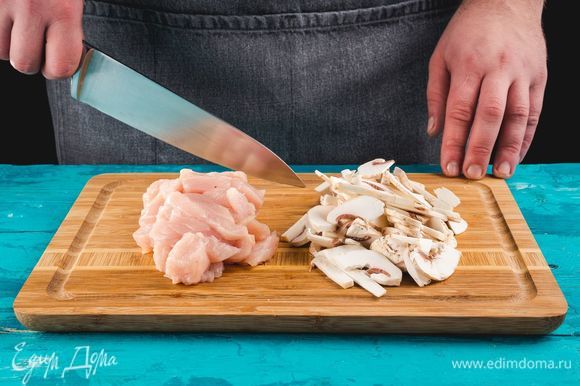 Разогрейте духовку до 200°С. Курицу и грибы нарежьте небольшими тонкими полосками.