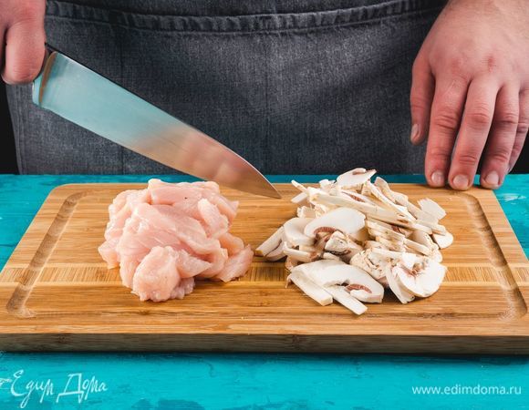 Разогрейте духовку до 200°С. Курицу и грибы нарежьте небольшими тонкими полосками.