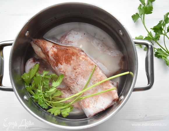 Кальмары залить кипятком, очистить от пленки, хорды, внутренностей и отварить в течение 2–3 минут.