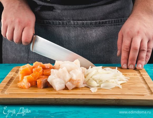 Разогрейте духовку до 160°С. Нашинкуйте лук и нарежьте рыбу небольшими кубиками.
