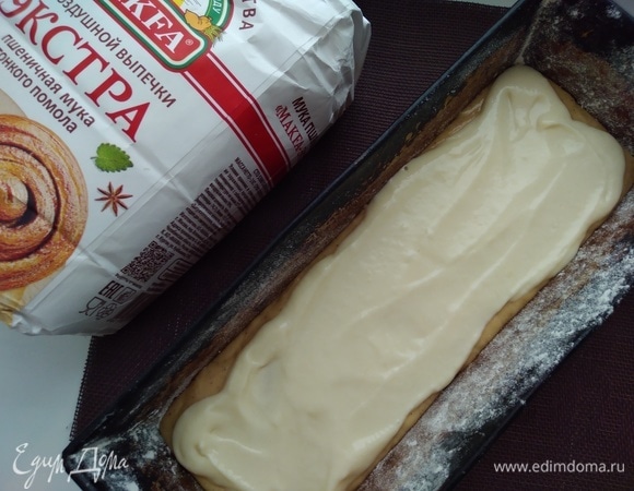 Духовку разогреть до 180°C. Приготовить прямоугольную форму. Смазать ее маслом и посыпать мукой, излишки стряхнуть. Влить 2/3 теста. Сверху аккуратно распределить начинку.