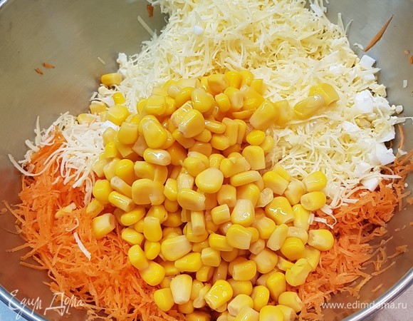 К моркови, сыру и яйцам добавить консервированную кукурузу.