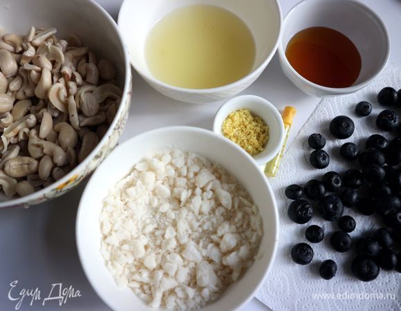 Лимон помыть, снять цедру с помощью мелкой терки. Выдавить лимонный сок. Слить воду с кешью с помощью дуршлага. Дать ему немного просохнуть. Голубику помыть, положить на бумажную салфетку.