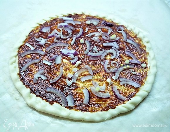 Смазываем заготовку соусом, поверх соуса выкладываем нарезанный маленькими колечками лук (я использовала крымский лук).