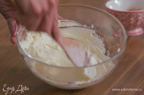 Приготовить крем, растерев сливочный сыр с сахарной пудрой. Оставшийся сахар всыпать в небольшую кастрюлю, слегка смочить его водой и сварить карамель.