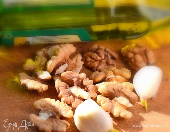 Готовим заправку: скалкой измельчаем грецкие орехи, натираем мелко чеснок, смешиваем с оливковым маслом и добавляем соевый соус.