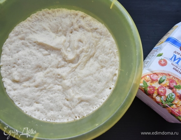 Выложить тесто в миску соответствующего размера. Миску заранее смазать растительным маслом. Оставить тесто подниматься на час в теплом месте. Из данного количества теста выйдет 2 больших пиццы.