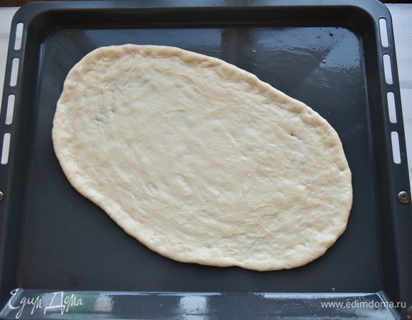 Противень слегка смазать растительным маслом. Каждую часть теста выложить на противень и руками распределить его, формируя овал.