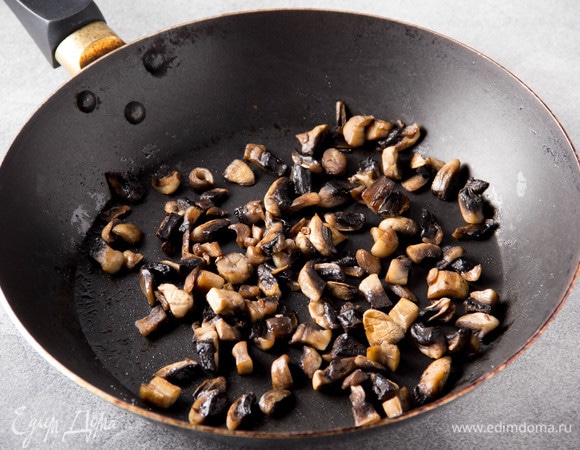 Шампиньоны очистить, нарезать кубиком и положить сначала на сухую разогретую сковороду. Когда сок выйдет, добавить масло и обжаривать 5 минут на среднем огне, посолить.