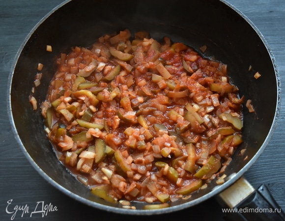 Репчатый лук нарезать кубиком. Соленые огурцы нарезать соломкой. В сковороде, где обжаривался картофель, пассеровать овощи. Добавить томатный соус или томатную пасту, разведенную водой. Посолить, поперчить, всыпать паприку. Потушить овощи минут 5–7.
