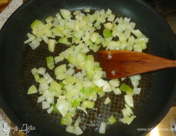 В большой сковороде (в идеале лучше взять ту, которая подойдет для последующего запекания) разогреть масло. Выложить нарезанный лук, томить немного.