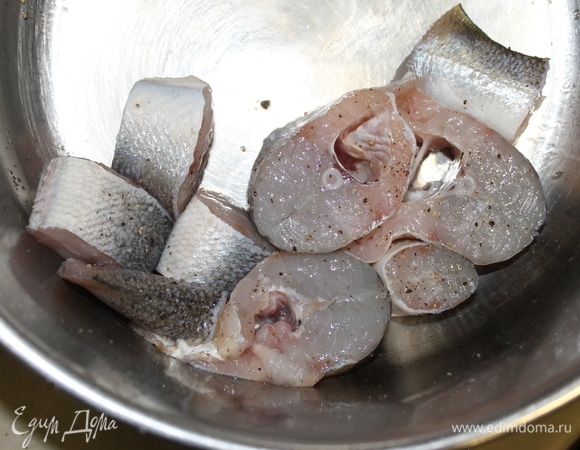 Для этого рецепта подойдет не только судак, а любая рыба, кроме речной. Очищенную рыбу выпотрошите, удалите жабры. Промойте ее в холодной воде, обсушите бумажным полотенцем и нарежьте поперек на кусочки толщиной 2 см. Посолите, поперчите и отставьте в сторону, дайте несколько минут ей постоять, чтобы растворилась соль.