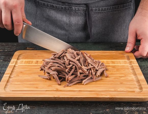 Язык отварите в подсоленной воде до готовности. Поместите в холодную воду, почистите и нарежьте тонкой соломкой.