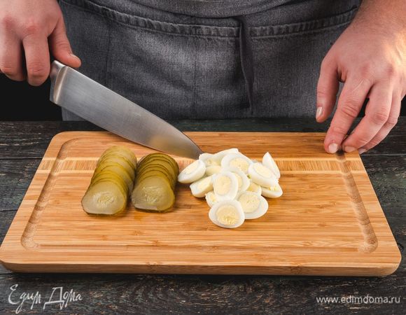 Перепелиные яйца отварите в течение 5 минут, поместите в холодную воду, почистите, разрежьте пополам. Соленый огурец нарежьте кружочками. 