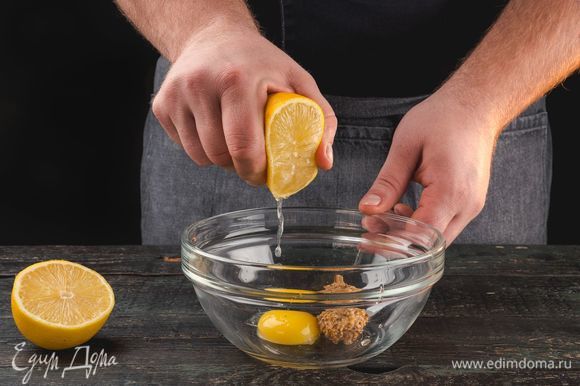 В емкости для взбивания смешайте желток, горчицу и лимонный сок.