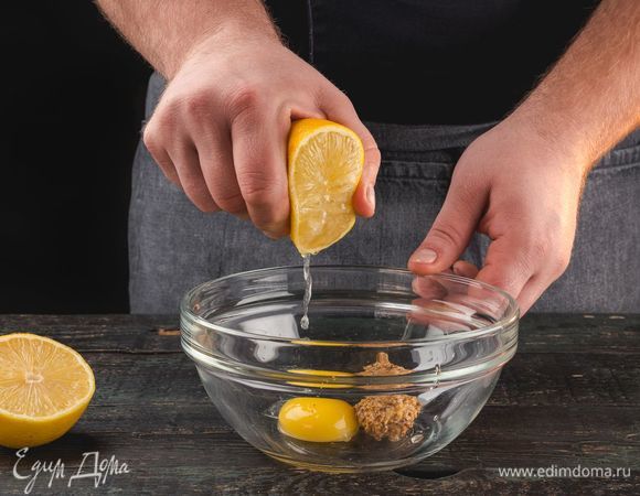 В емкости для взбивания смешайте желток, горчицу и лимонный сок.