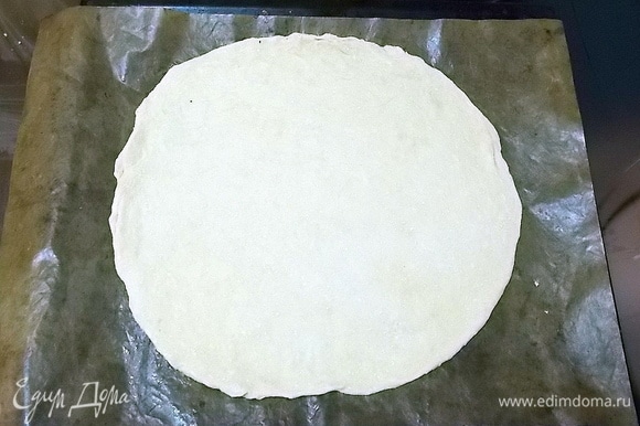 Раскатываем тесто в круг и укладываем на смазанный маслом противень или на коврик для выпечки.