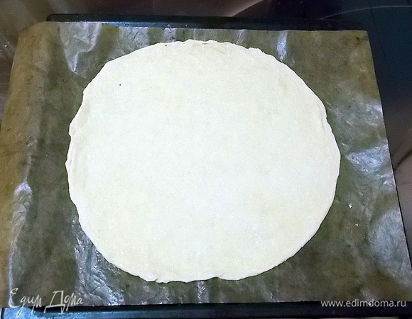 Раскатываем тесто в круг и укладываем на смазанный маслом противень или на коврик для выпечки.
