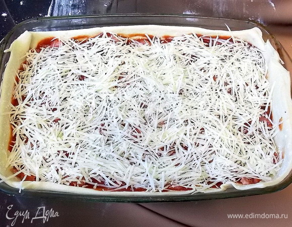 Посыпьте пиццу тертым пармезаном.