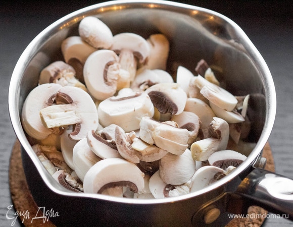 Шампиньоны очистить, нарезать слайсами и добавить в сотейник. Обжаривать вместе с луком и морковью, пока шампиньоны не отдадут почти весь свой сок.