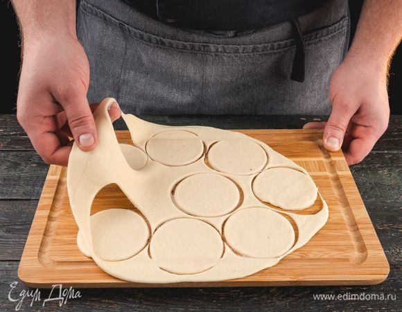 Тесто для пельменей раскатайте в пласт. Спомощью стакана вырежьте круглые заготовки.