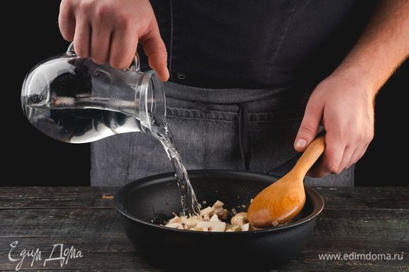 Обжарьте грибы и лук на сковородке с маслом до румяного цвета, затем закройте крышкой, потомите 3 минуты. Добавьте воды. Тушите еще 7 минут под крышкой. Затем откройте крышку на 3–5 минут, чтобы выпарилась вода.