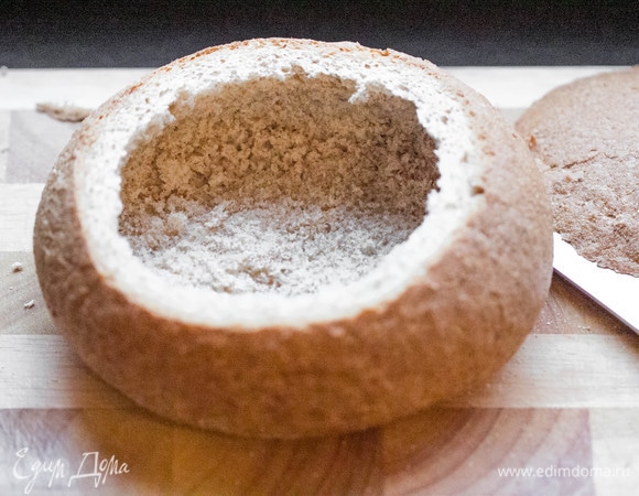 Пока готовится суп, подготовим хлеб. Срезать верхушку хлеба и достать мякиш, оставив небольшой слой по бокам и на дне. Подрумянить хлеб в духовке при температуре 220°C в течение 10 минут.