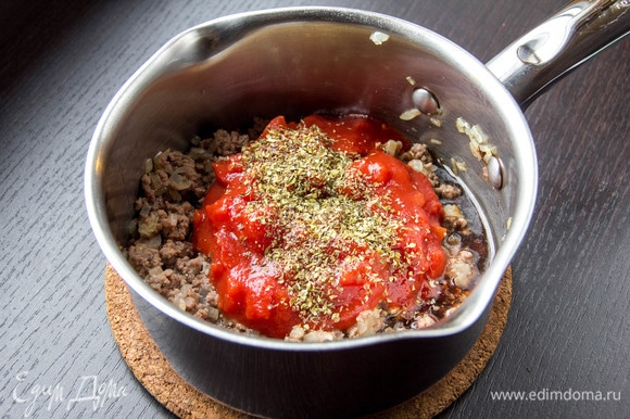 Добавить томаты в собственном соку (вместе с соком). Приправить смесью перцев, солью и сушеными травами.